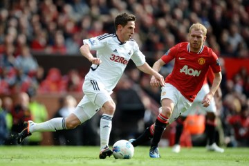 Image: Joe Allen of Swansea City competes with Paul Scholes of Manchester United during the Barclays Premier League match at Old Trafford in Manchester, England on May 6, 2012.