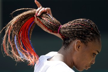 Venus Williams adjusts her hair, which contains red and blue strands, during practice at the All England Lawn Tennis Club at Wimbledon