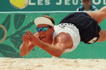 image: Sinjin Smith lunges to get the ball during the preliminary Olympic beach volleyball match against Portugal at the 1996 Summer Olympic Games in Atlanta, July 26, 1996.