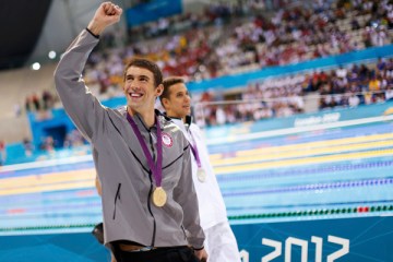 Michael Phelps of the U.S. celebrates with his gold medal after winning the men's 100m butterfly final during the London 2012 Olympic Games at the Aquatics Centre, Aug. 3, 2012.