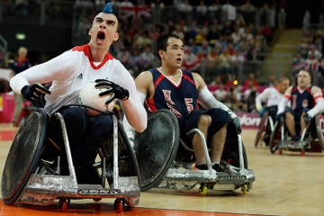 Britain's David Anthony, left, celebrates after scoring past Chuck Aoki, right, of the United States during a wheelchair rugby preliminary match at the 2012 Paralympics, Wednesday, Sept. 5, 2012, in London.