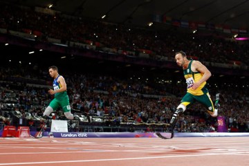 Brazil's Alan Fonteles Cardoso Oliveira, left, runs in to win the gold medal and beat South Africa's Oscar Pistorius, who took the silver medal in the men's 200m T44 category final during the athletics competition at the 2012 Paralympics, Sept. 2, 2012.